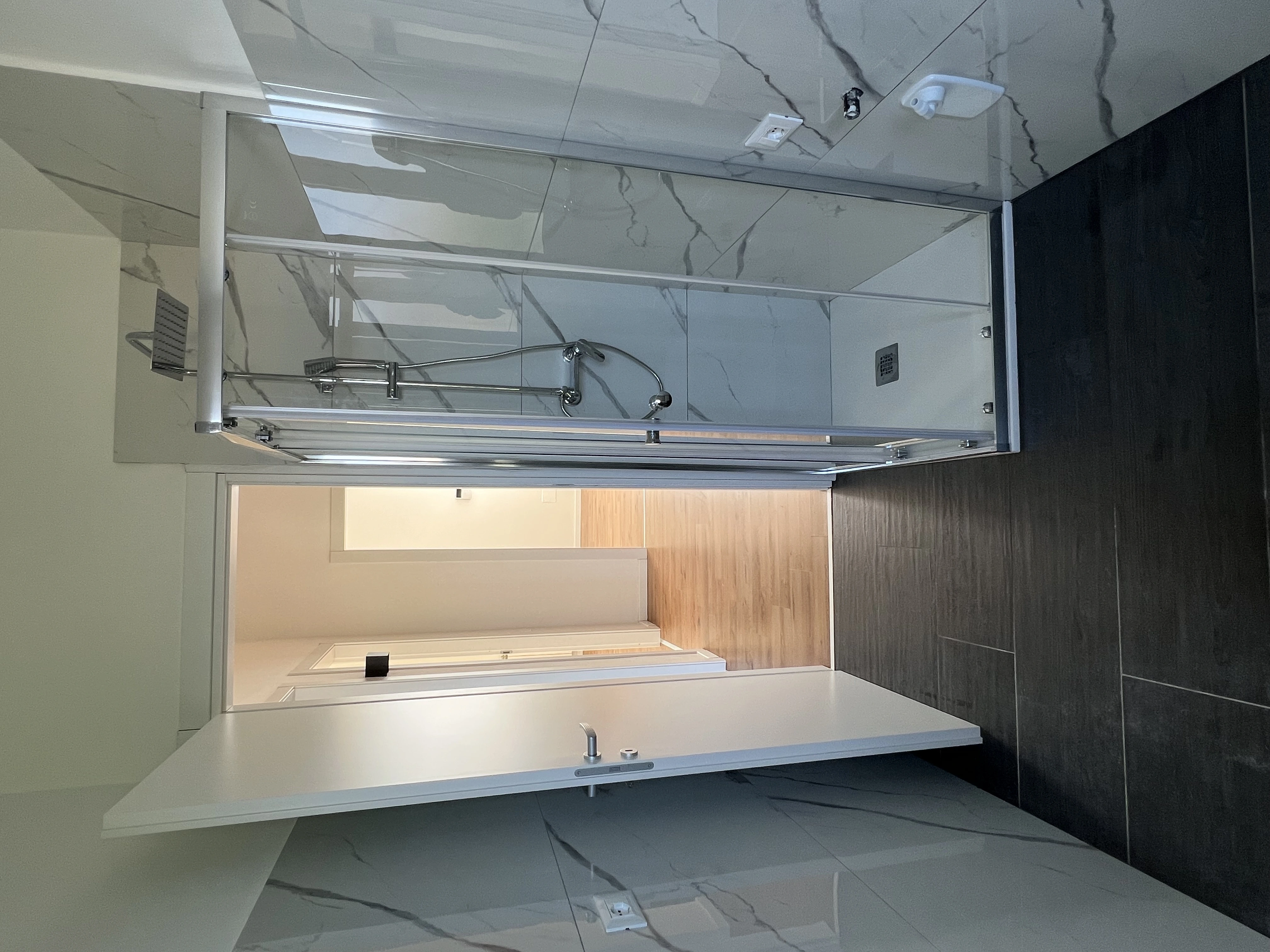 Soffitto in cartongesso stuccato, cavi elettrici pendenti e pareti grezze durante la ristrutturazione di bagni e cucine