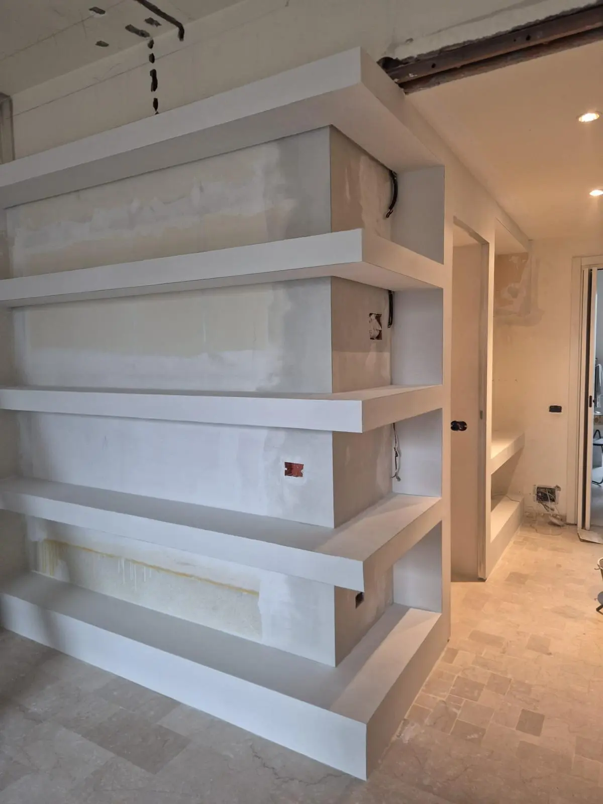 Scaffalatura in cartongesso su misura in fase di finitura, con vani aperti e predisposizioni elettriche.