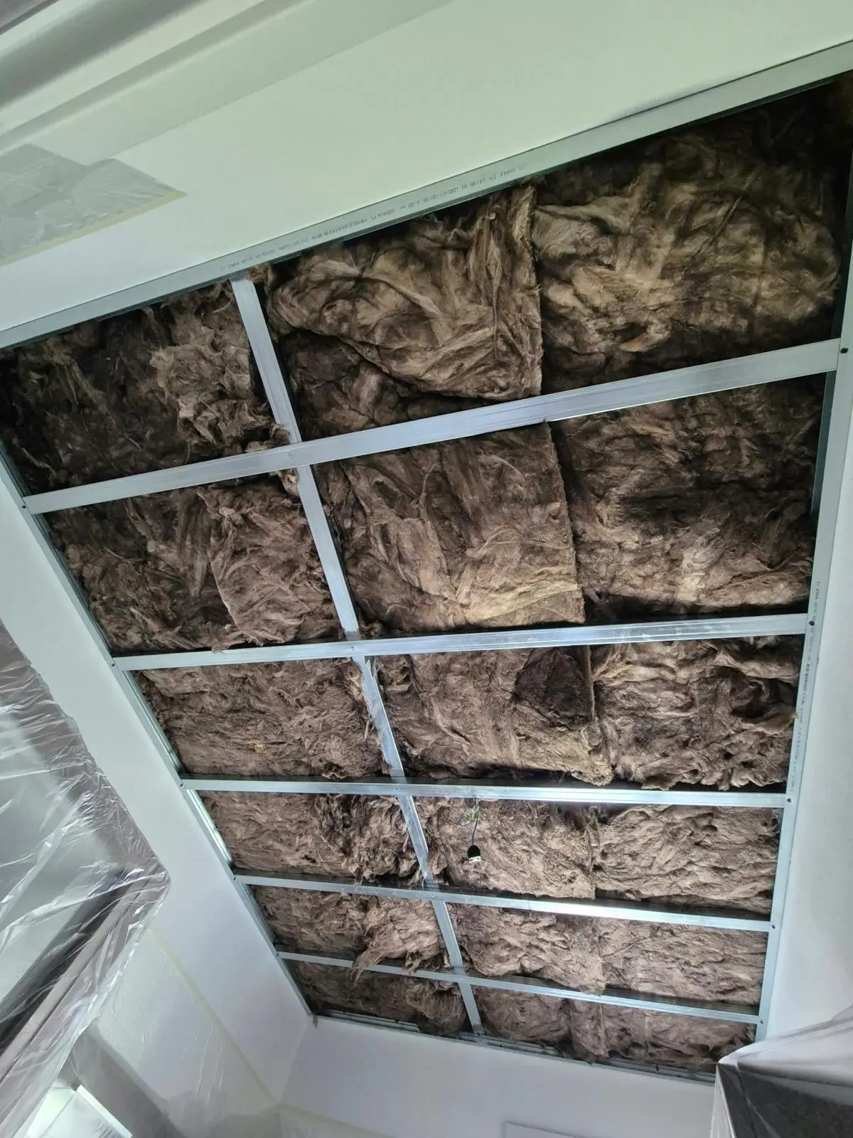 Pannelli di lana minerale inseriti nella struttura metallica di un controsoffitto in lavorazione.
