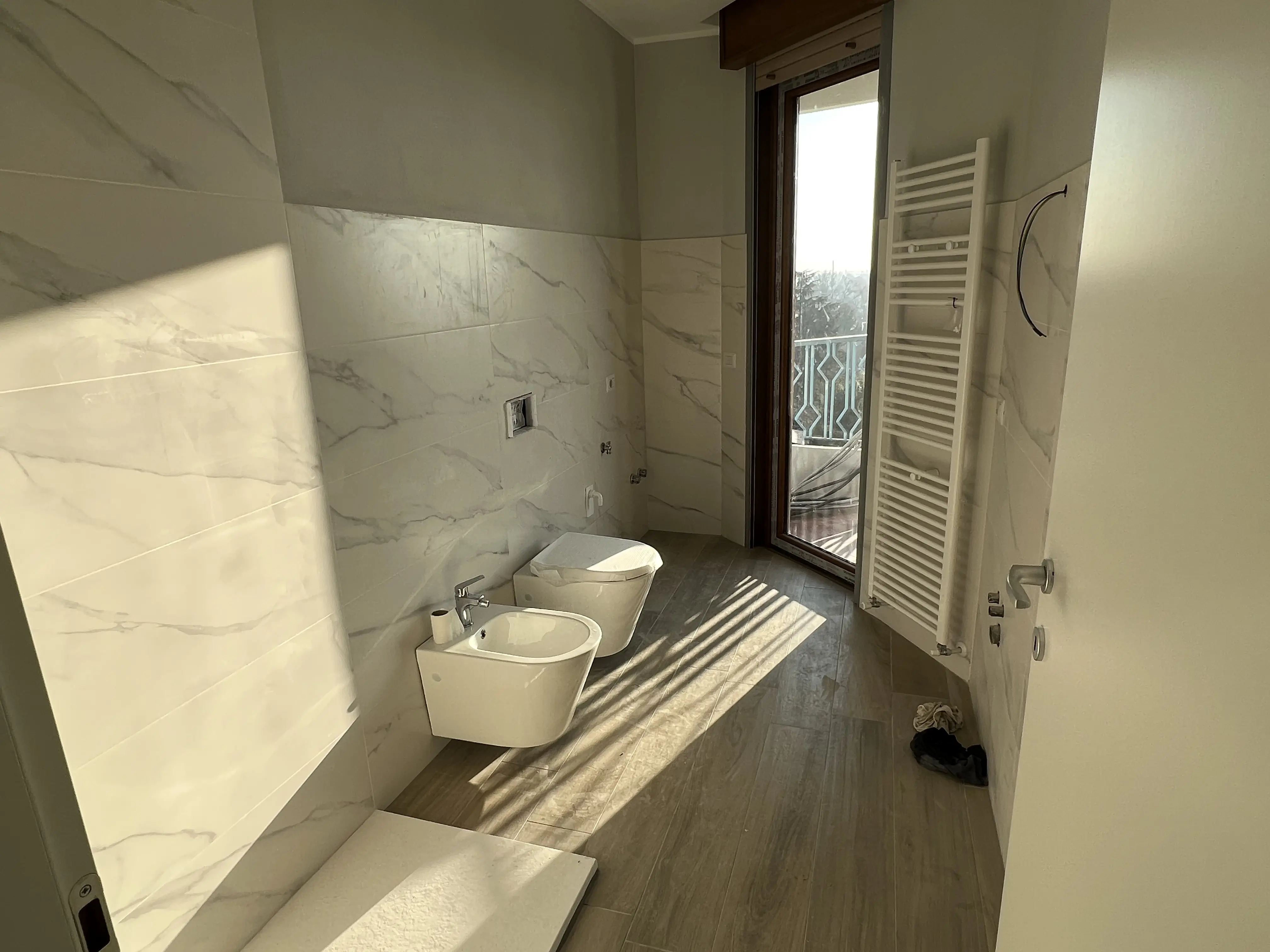 Bagno ristrutturato con piastrelle effetto marmo da Maestro Edilizia | Ristrutturazione Casa a Milano.