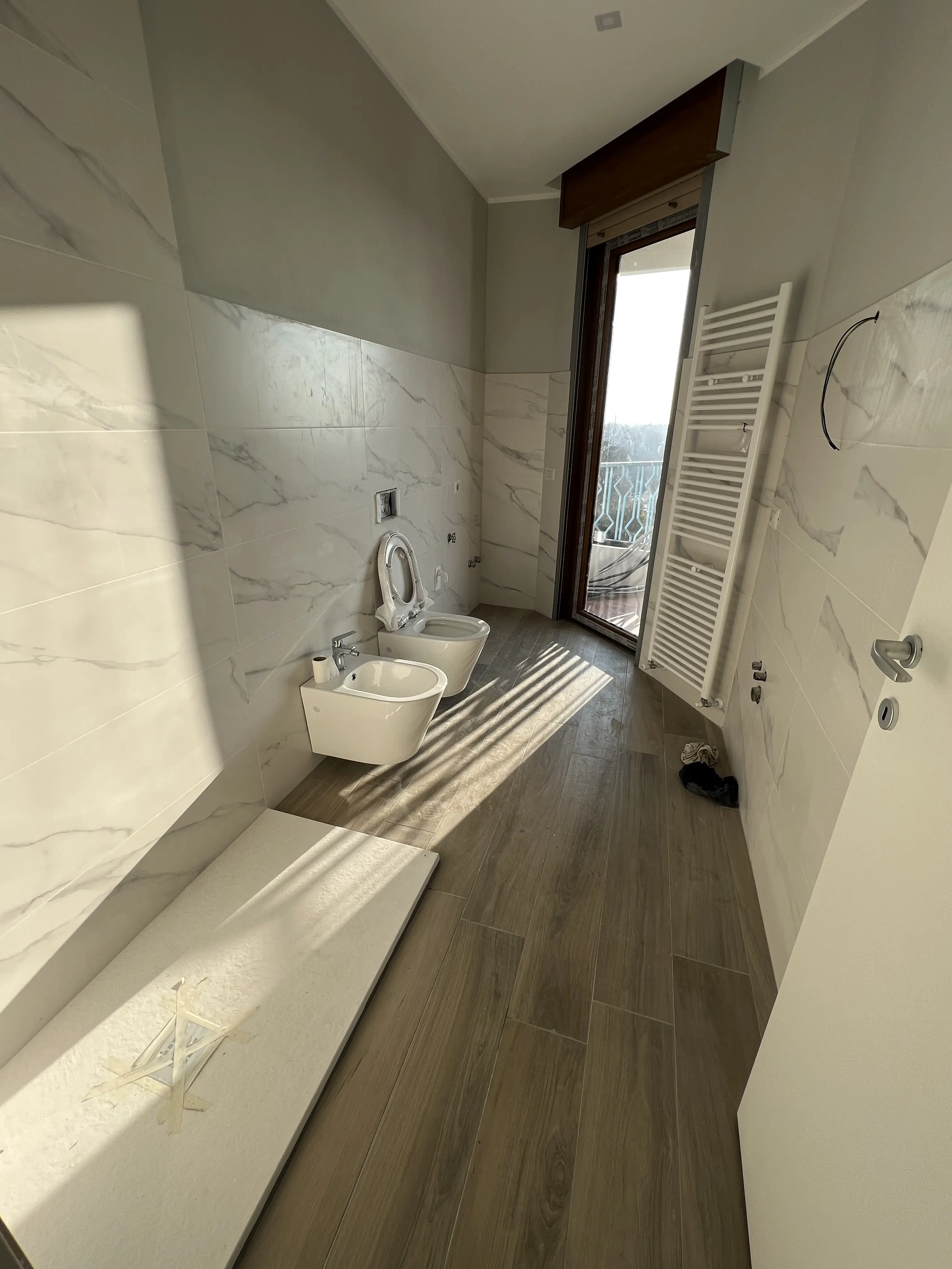 Bagno ristrutturato con piastrelle effetto marmo da Maestro Edilizia | Ristrutturazione Casa a Milano.