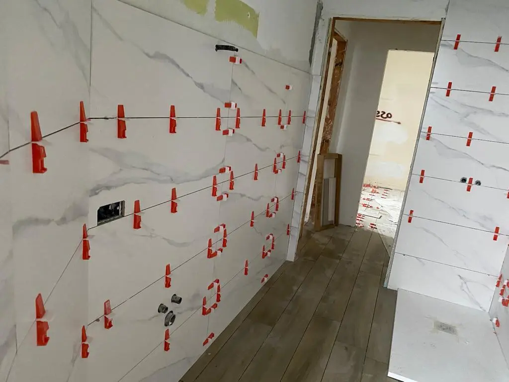 Posa in corso di rivestimenti effetto marmo da Maestro Edilizia | Ristrutturazione Casa a Milano.