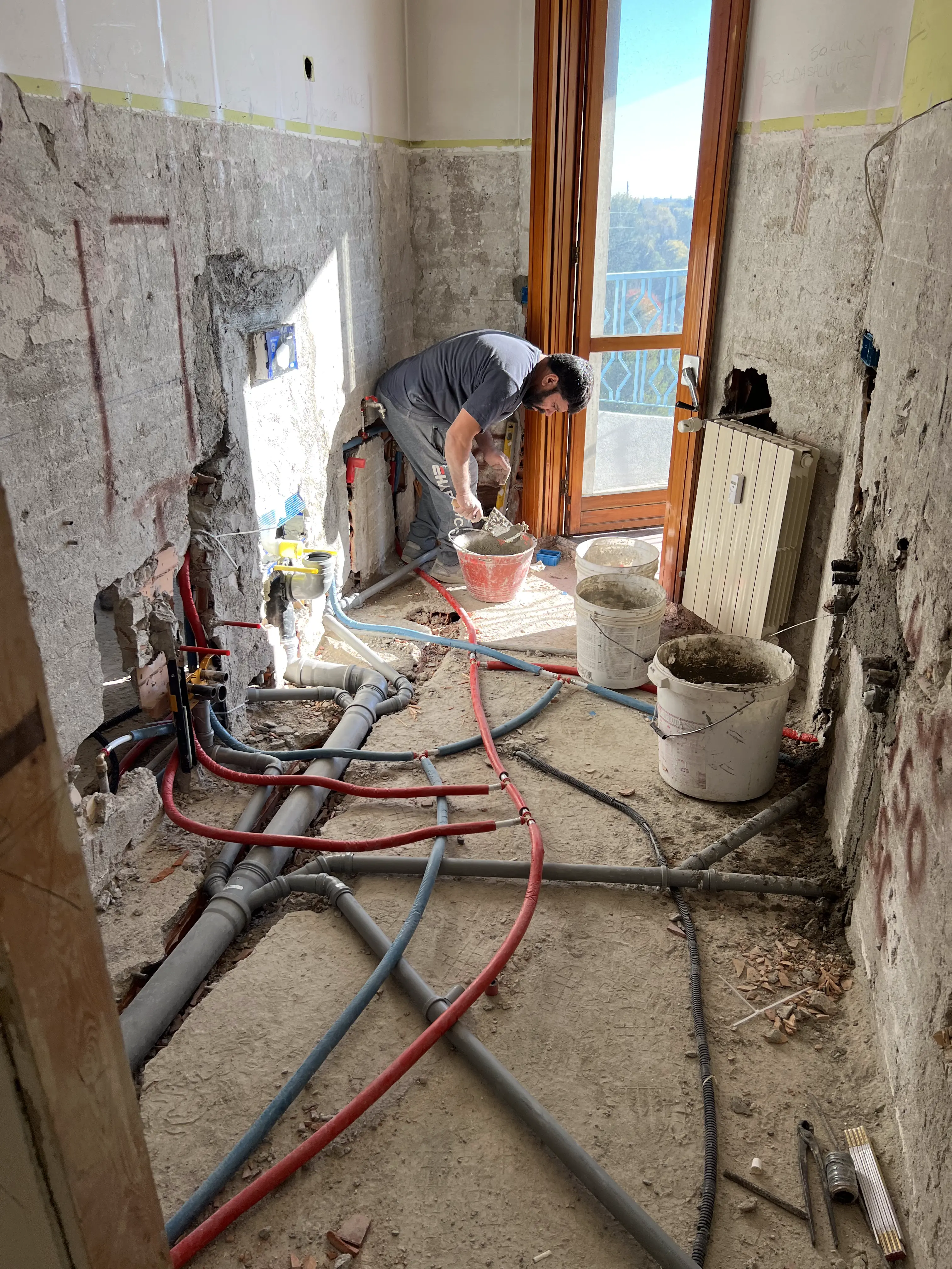 Operaio posa nuovi impianti durante una ristrutturazione casa di Maestro Edilizia a Milano.