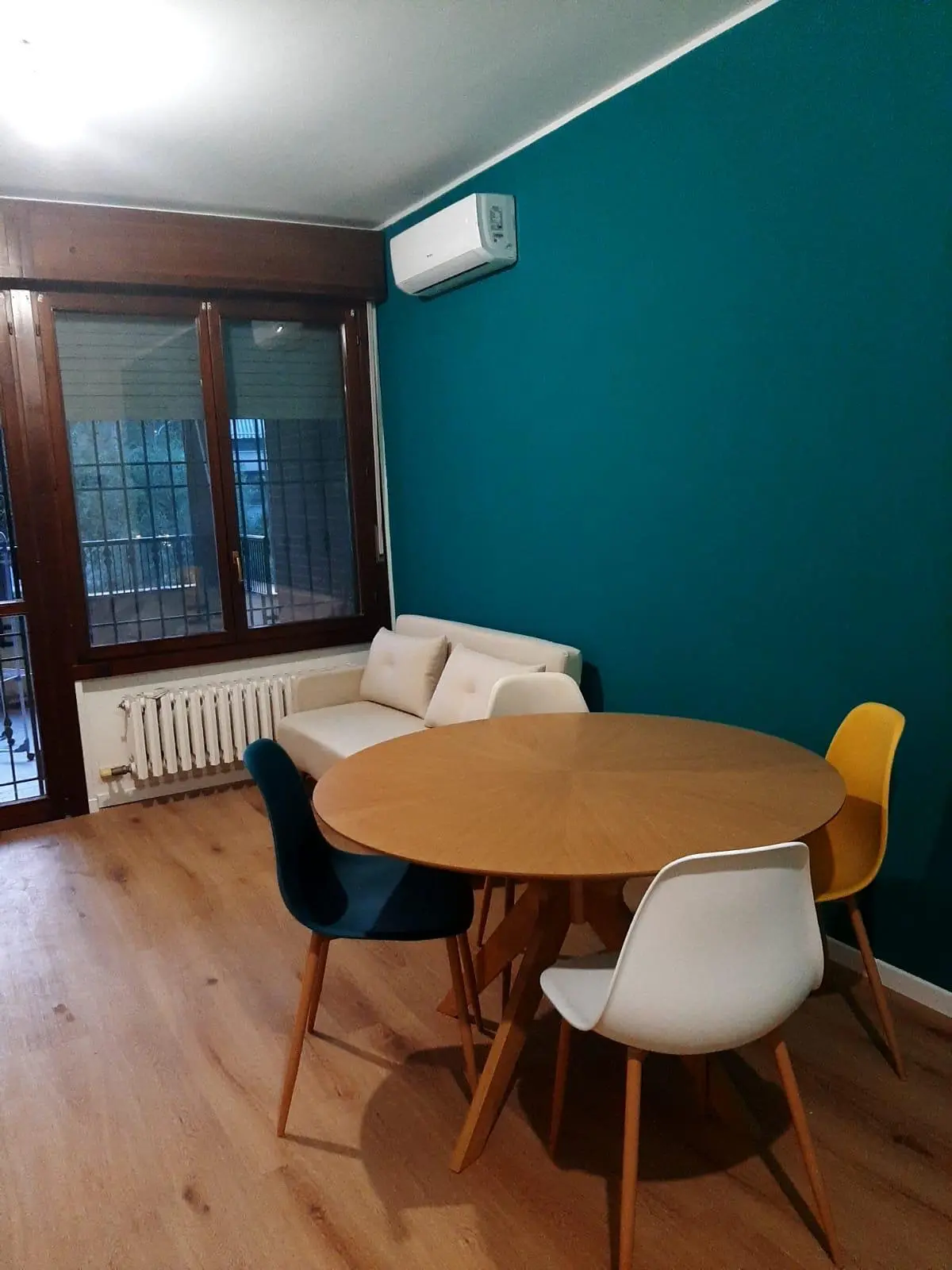 Sala da pranzo ristrutturata con parete verde e parquet da Maestro Edilizia | Ristrutturazione Casa a Milano.