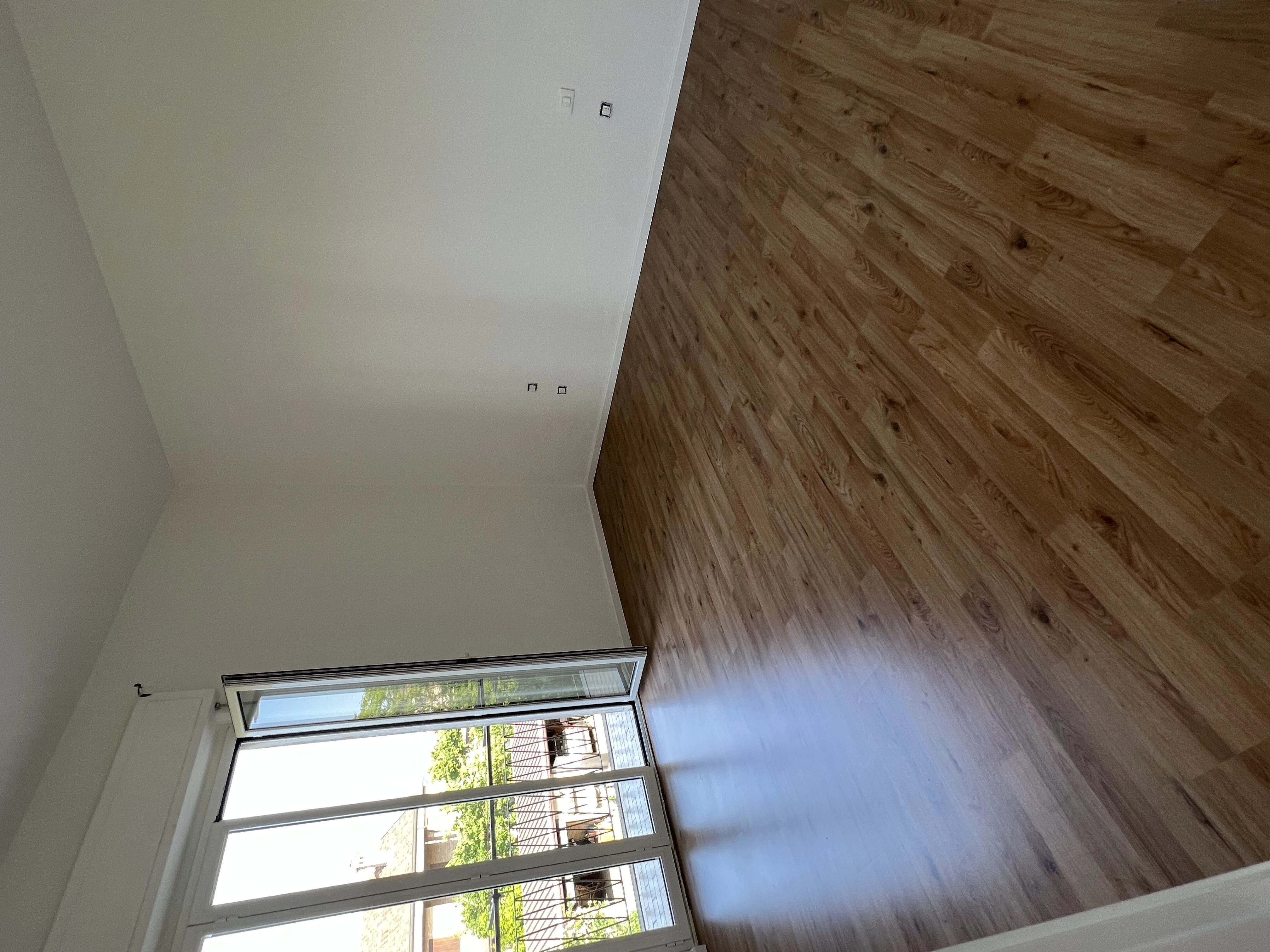 Soggiorno ristrutturato con parquet e portafinestra da Maestro Edilizia | Ristrutturazione Casa a Milano.