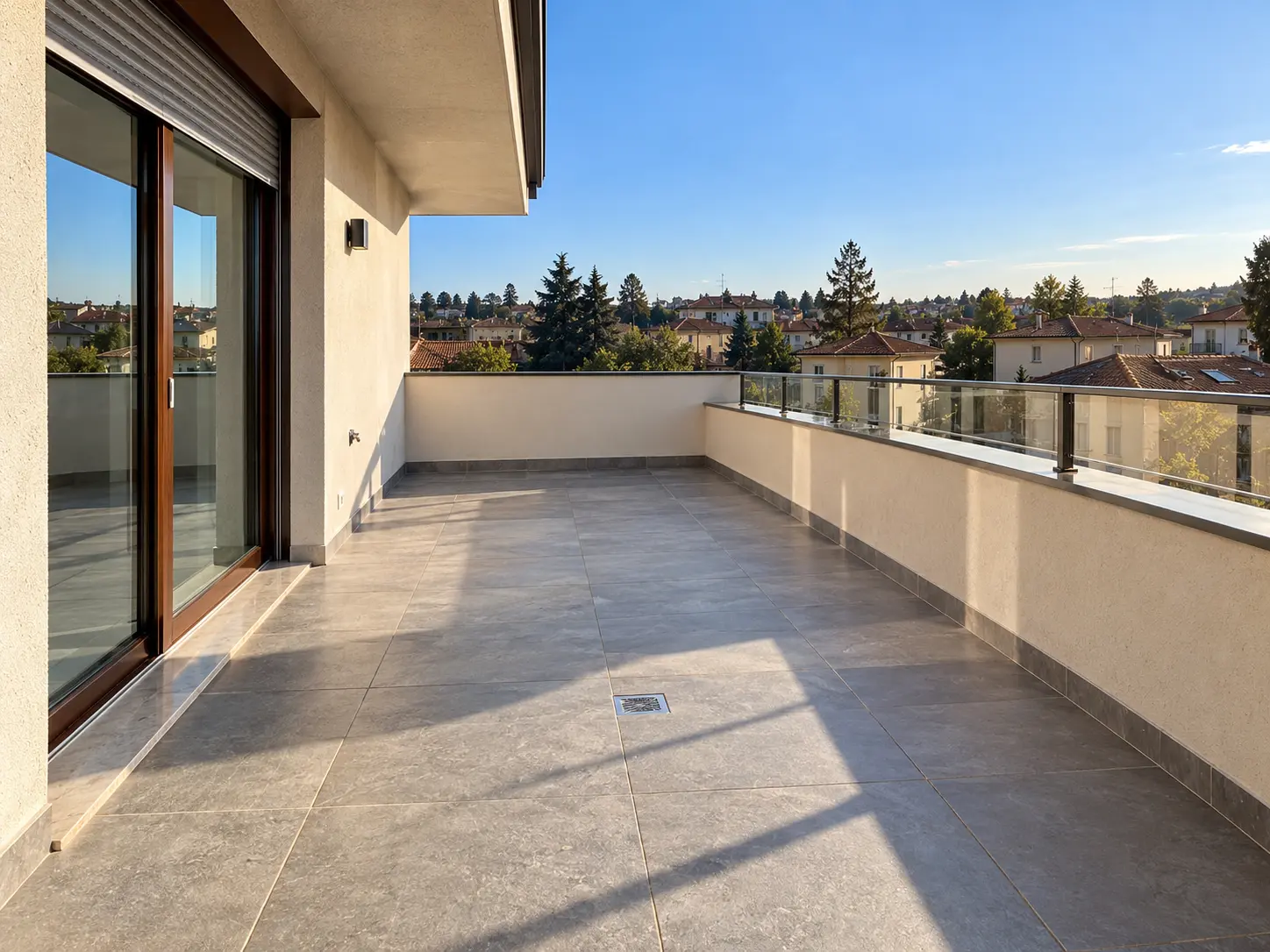 Terrazza con pavimento in gres e parapetto in vetro, ristrutturata da Maestro Edilizia | Ristrutturazione Casa a Milano.
